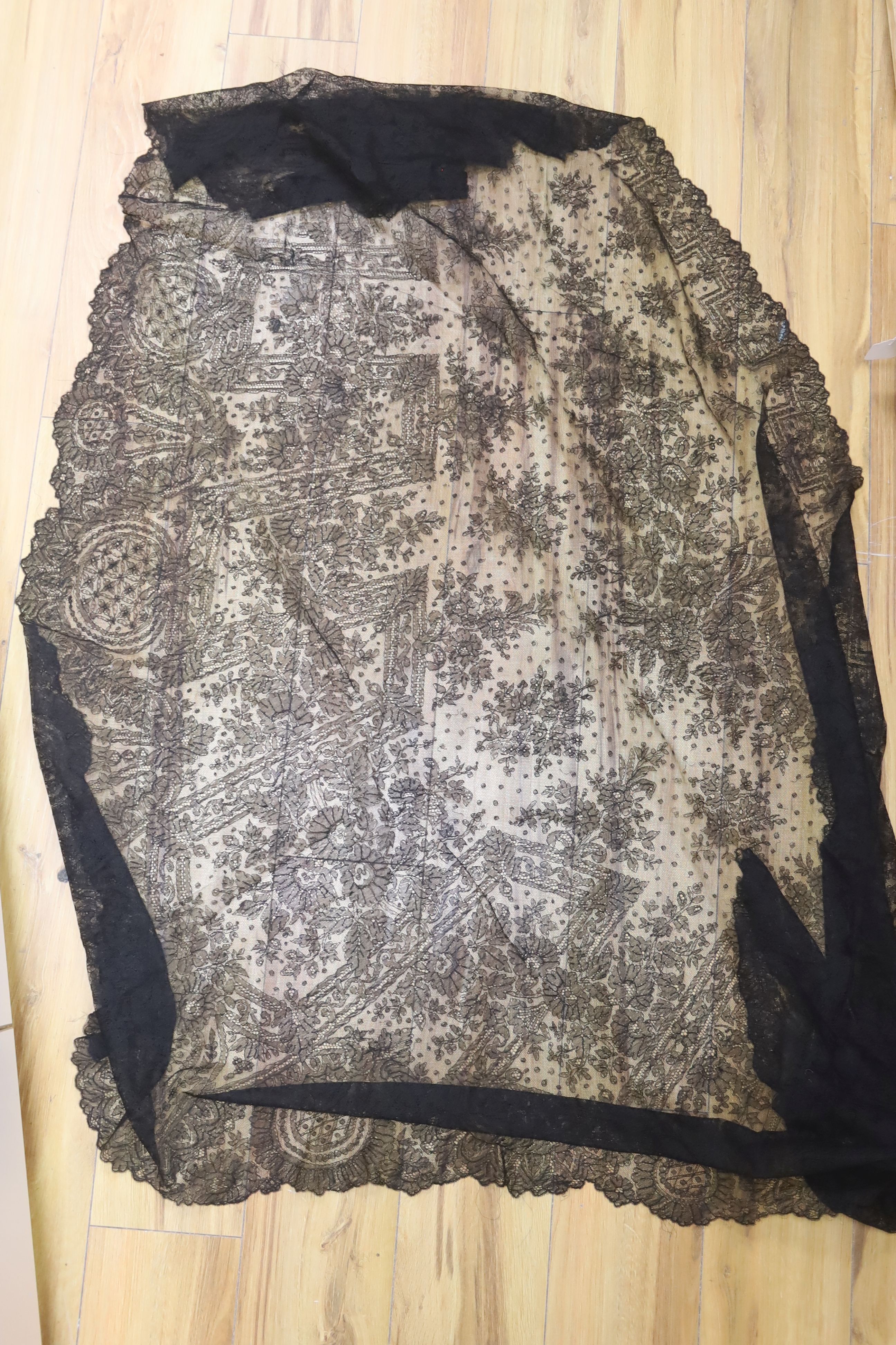 A black lace mantilla, filet and cutwork table cloth and a pair of 19th century silk jodhpurs